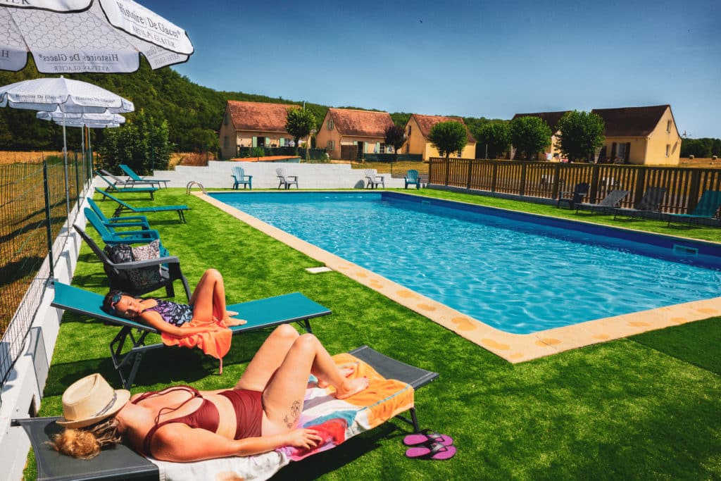 Piscine extérieure avec transats et parasols.