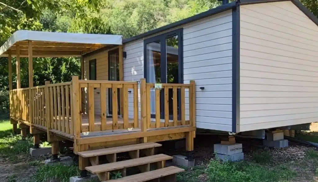 Mobil-home avec terrasse en bois dans la forêt.