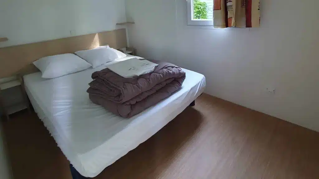 Lit avec draps et coussins dans une chambre
